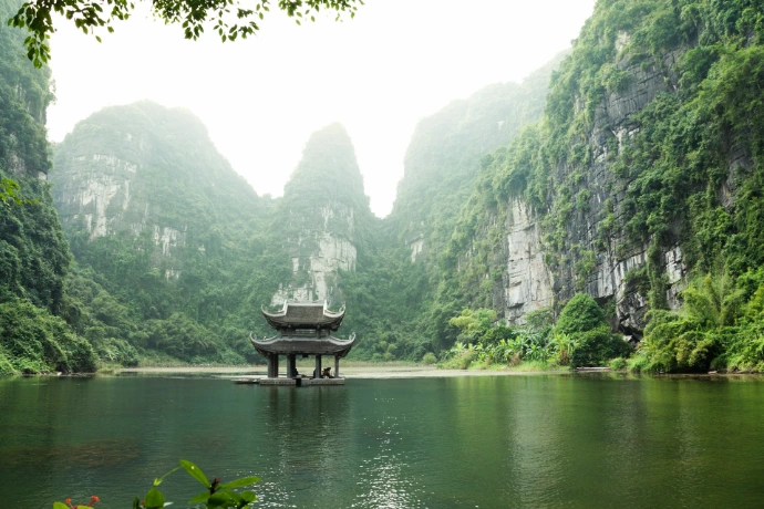 Vietnam pagoda surrounded by body of water and mountains